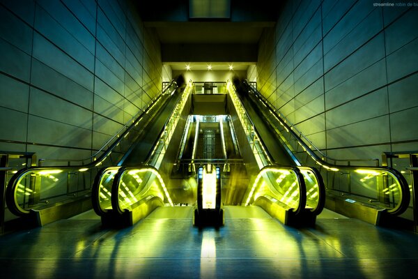 Inusual iluminación verdosa de una escalera mecánica vacía