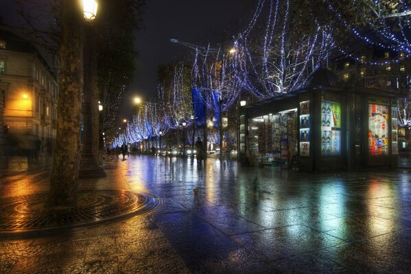 Eine Nachtstadt mit nassem Asphalt nach Regen, in der die Lichter von Schaufenstern, Fenstern und Laternen reflektiert werden