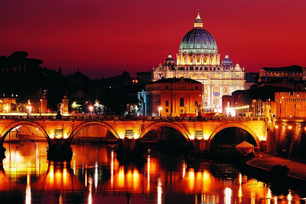 Amsamble di edifici turchi sullo sfondo di un tramonto scarlatto con un ponte sul fiume