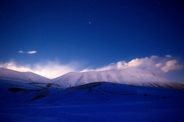 Fusión de cielos azules con picos nevados de montañas