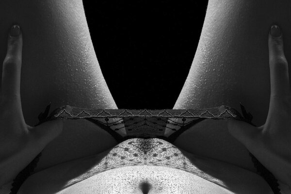 Foto in bianco e nero di una ragazza erotica accovacciata mutandine