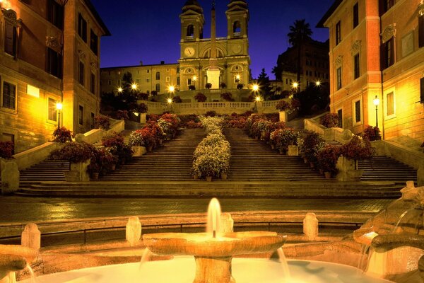 Lights of the night city. Fountain at the church in Rome