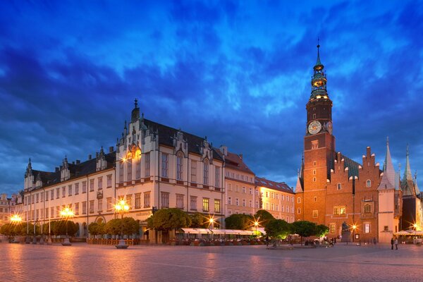 Abendstadt mit goldenen Lichtern auf dem Hintergrund eines blauen bewölkten Himmels überflutet