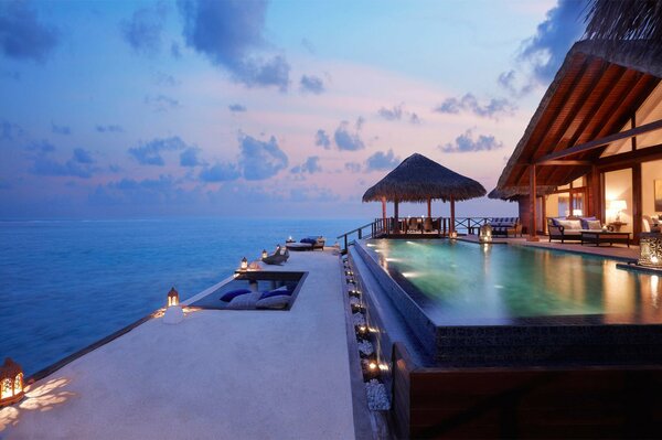 Sunset on the sea at the house with a swimming pool