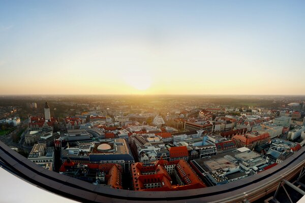 Dawn from the roof reveals a panoramic view of the city . The sun rises from the horizon