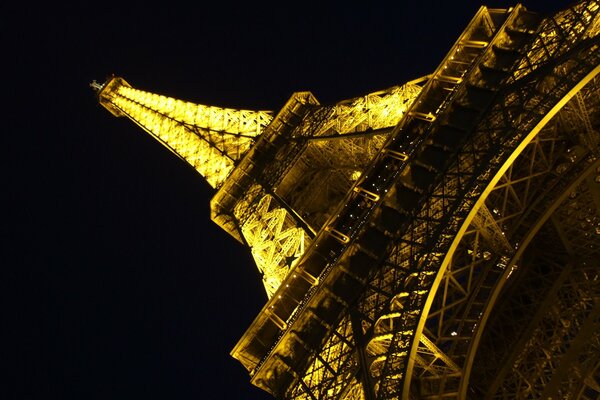 La torre Eiffel nocturna en un ángulo inusual - vista desde abajo