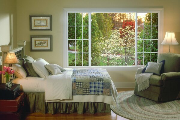 Elegante dormitorio con gran ventana con vistas a la vegetación