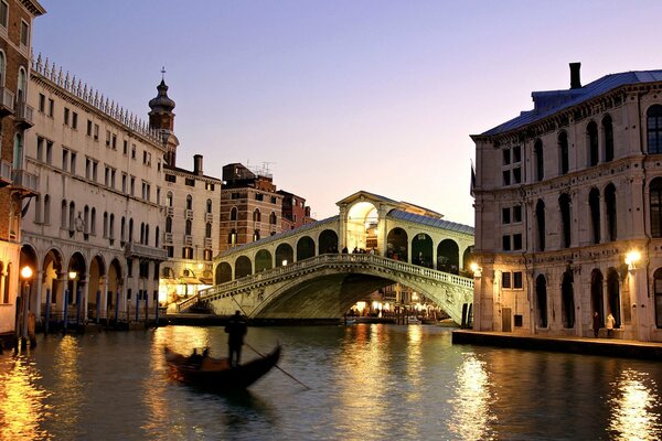 Gondola at the bridge in Venice at sunset