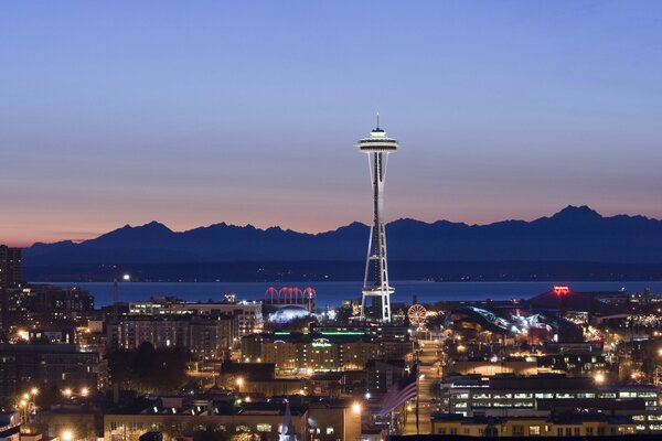 Torre de Seattle vespertina y lejos de las montañas