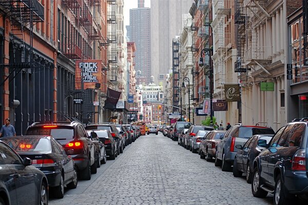 Calle de la metrópoli durante el día. muchos coches a los lados de la carretera