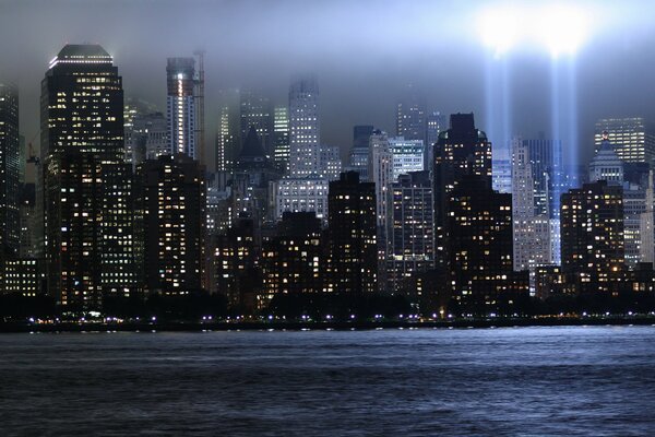Luci notturne di New York con fasci di luce