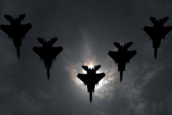 Five fighter jets in a cloudy sky