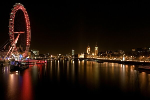 Das Riesenrad spiegelt sich in den dunklen Gewässern des Flusses wider. London