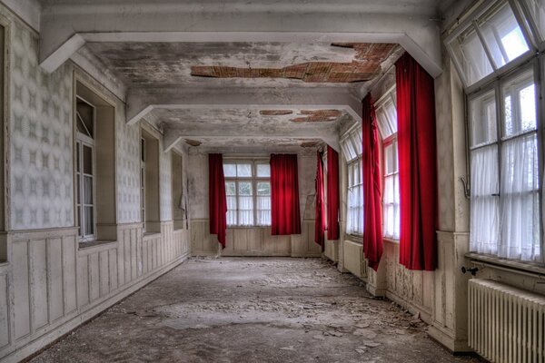 Habitación vacía de estilo retro con cortinas rojas en las ventanas