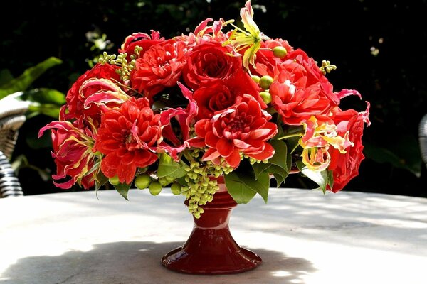 Bouquet di fiori rossi lussureggianti in un vaso