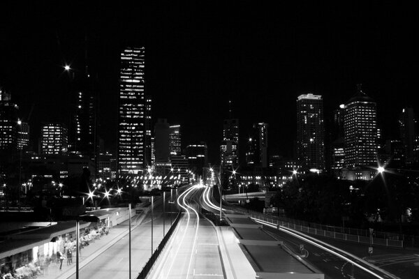Eine schwarz-weiße Straße, die von den Lichtern der Großstadt beleuchtet wird