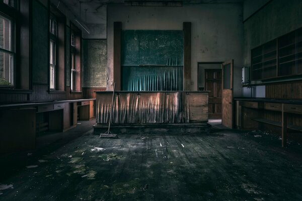 An empty classroom with empty cabinets, stripped floors and walls