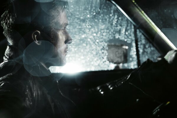 Hombre en coche por la noche y bajo la lluvia