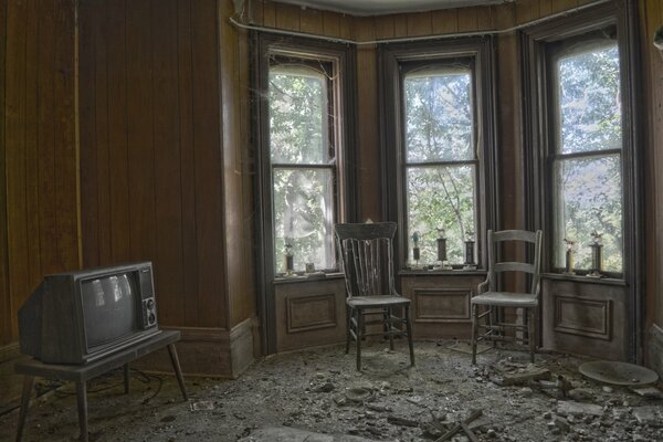 Photo de la télévision, des fenêtres et des chaises dans la chambre