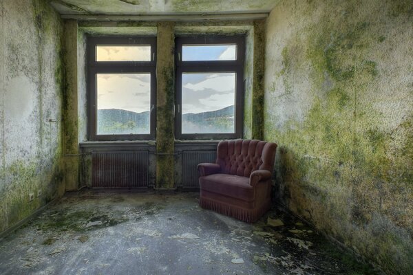 Pink armchair on the background of old walls and windows