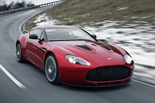 Red Aston Martin rides from a height