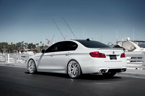 Un BMW blanco contra un yate blanco