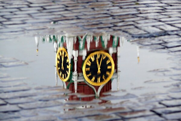 Reflejo del reloj en las torres del Kremlin en el charco