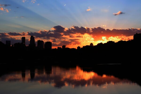 Beau coucher de soleil sur la ville se reflète dans l eau