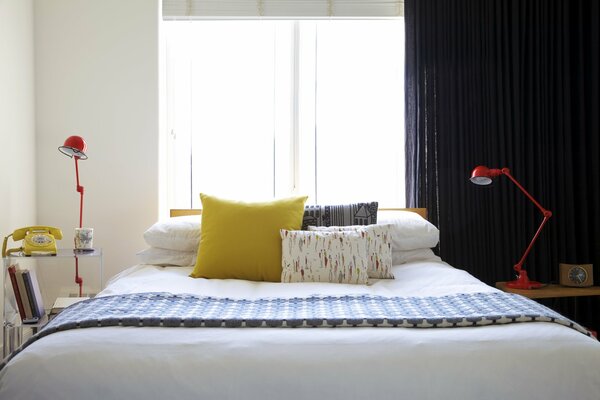 Sypialnia z łóżkiem i żółtą poduszką