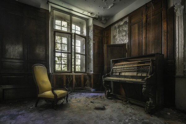 Silla y piano en una casa abandonada