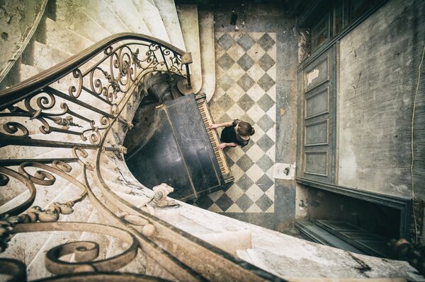 A girl plays the piano in an old house