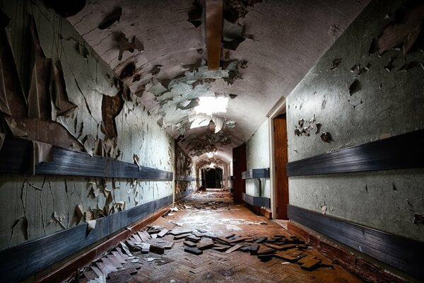 A long dirty corridor with broken parquet