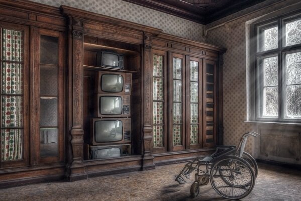 Habitación con televisores viejos con silla