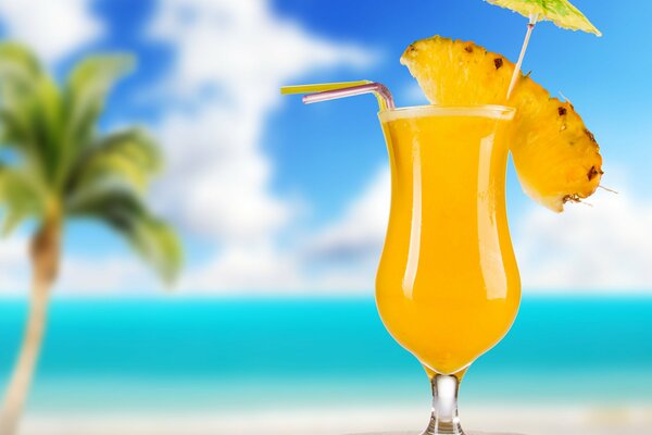 Ein Glas Ananas-Cocktail auf Strandhintergrund