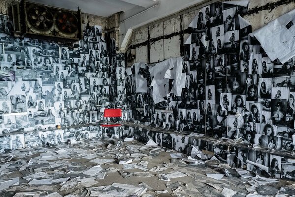 La chambre est finie avec des photos et une chaise rouge