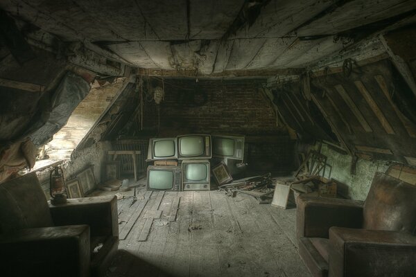 A scary old attic with televisions and other items