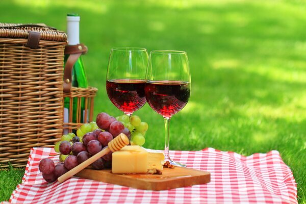 Glasses with wine and cheese in nature