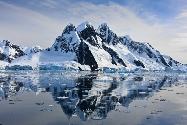 Reflexion von schneebedeckten Felsen im Wasser