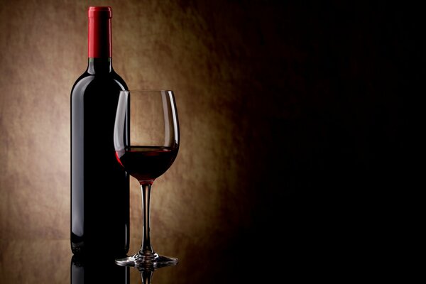 Eine Flasche Rotwein und ein Glas Weinglas mit gegossenem Wein