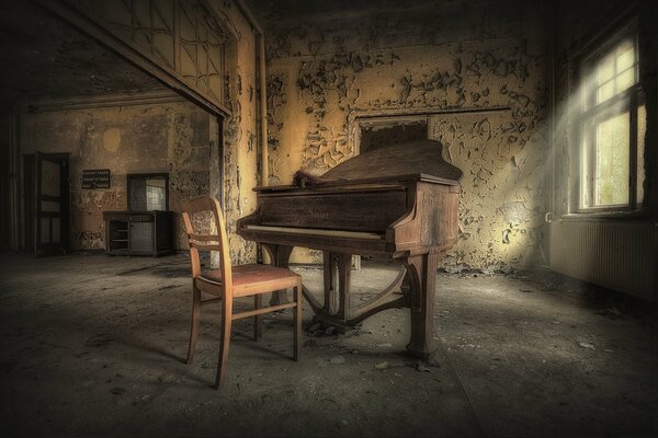 Piano y silla en una habitación antigua con una ventana