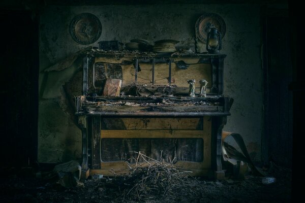 Una habitación con un piano viejo desmontado y estatuillas en él