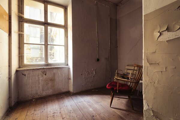 Старая комната с большим окном и стулом