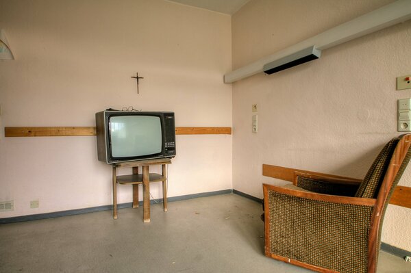 A room with a TV and an armchair