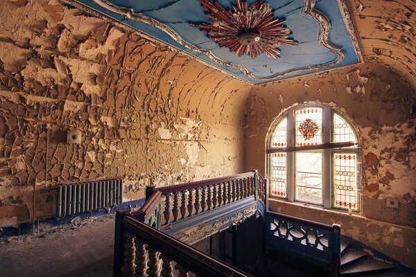 An old staircase with shabby walls and a window