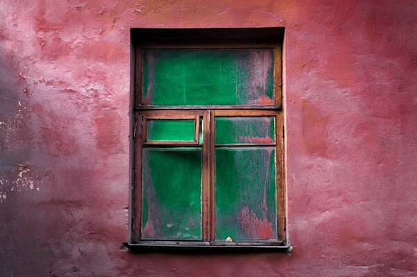 Pared roja con ventana de madera vieja