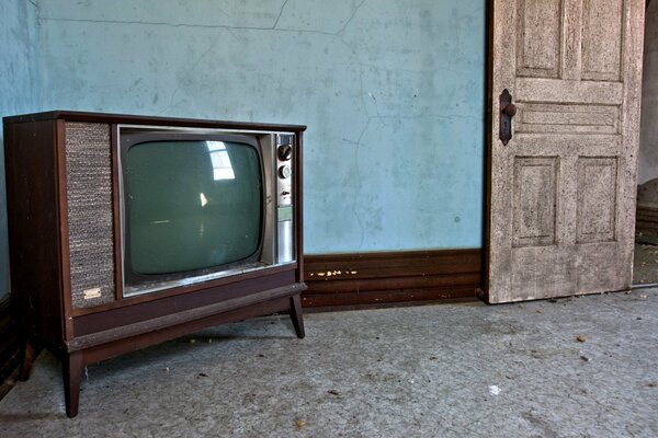 Chambre avec ancienne télévision et porte ouverte