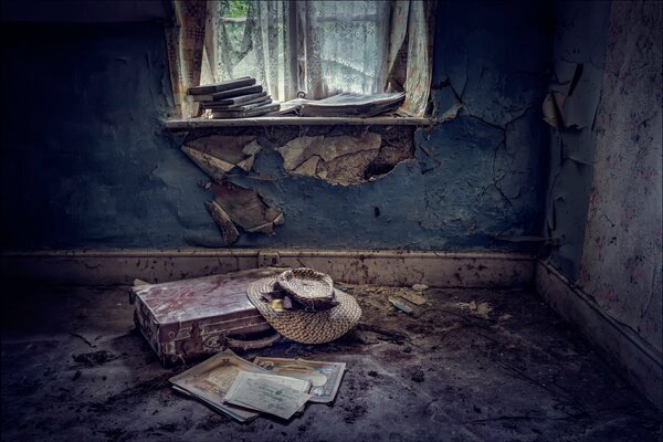 A hat on a suitcase in a scary room