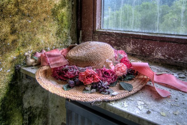 Sombrero con flores en el fondo de la ventana