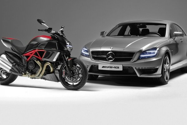 La moto Ducati en el fondo del coche Mercedes