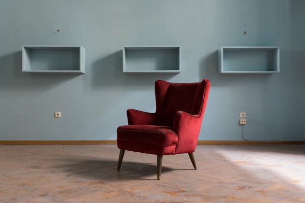 Fauteuil rouge sur fond de mur bleu